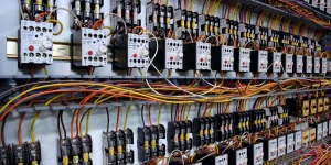 Close-up view of an industrial electrical control panel with neatly arranged circuit breakers and colorful wiring for manufacturing efficiency