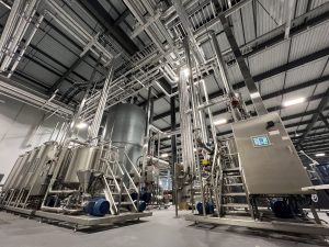 Technicians installing commercial ovens and chillers in a food manufacturing plant