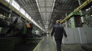 industrial plant or warehouse with visible equipment and workers in safety gear.